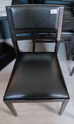 a black chair that is sitting in front of a piano
