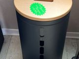 a black trash can with a green sticker on it next to a laptop