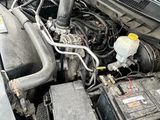 une voiture rouge dont le capot et le compartiment moteur sont ouverts