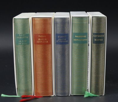 four books are lined up in a row on a black surface