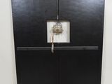 a clock on the wall with a birdcage hanging from it
