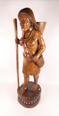 statue en bois représentant une femme tenant un bâton et un panier
