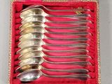 six spoons in a red box with a gold border