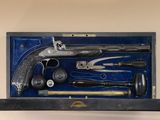 a box with a gun, a hammer, a hammer, a hammer, and other items in it