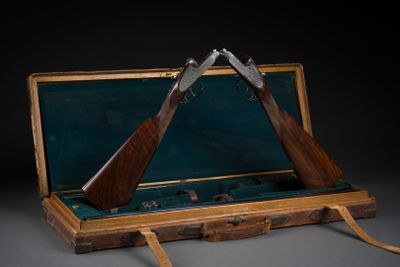 deux armes à feu qui se trouvent dans un étui posé sur une table