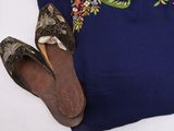 pair of brown shoes and a blue dress with floral embroidery on it