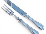 two forks and a knife on a white surface