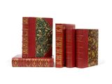trois livres rouges superposés sur une surface blanche