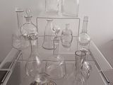 une table en verre sur laquelle sont posés de nombreux vases en verre