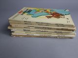 several children ' s books stacked on top of each other on a table