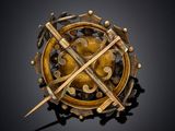 a close up of a gold broochle on a black background