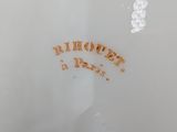a close up of a white vase with a brown writing on it