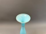 un vase en verre bleu orné d'une bordure dorée