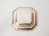 a silver plate on a white table with a white background