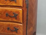 une petite commode en bois sur fond gris