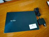 un ordinateur portable posé sur une table avec un chargeur