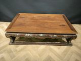 an old wooden coffee table with ornate carvings on the top