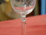 a wine glass sitting on a table with a red table cloth