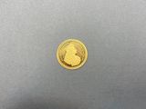 gros plan d'une pièce d'or sur une surface grise