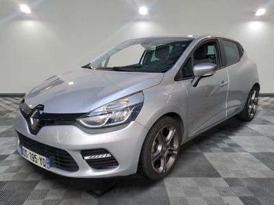 une voiture argentée est garée dans une pièce au sol en damier