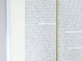 an open book sitting on top of a table next to a cup of coffee