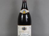 la bouteille de vin est posée sur la table à côté du verre