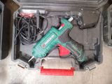 a green cordless drill in a case with other tools