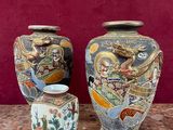 trois vases posés sur une table, avec un mur rouge en arrière-plan