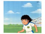 cartoon image of a boy in a soccer uniform running with a soccer ball in his hand