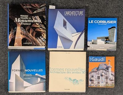 plusieurs livres posés sur un tapis, avec un bâtiment en arrière-plan