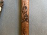 a wooden stick with a picture on it next to a wooden stick with a picture on it