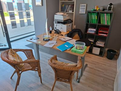 un bureau avec deux chaises et un ordinateur dessus