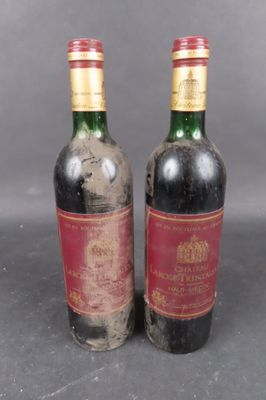 two bottles of wine sitting next to each other on top of a table