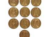 a close up of a bunch of gold coins on a white surface