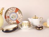many different types of teapots and saucers on the table