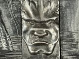 a close up of a carving of a man ' s face on a bench