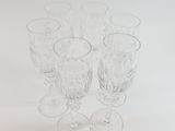 several empty wine glasses are lined up on a white surface