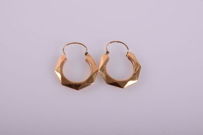 a pair of gold hoop earrings on a white background