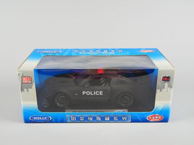 une petite voiture de police en jouet dans une boîte, posée sur une surface blanche