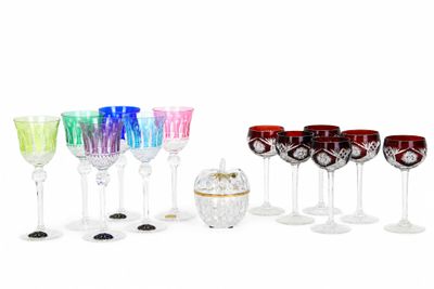 de nombreux verres à vin de différentes couleurs alignés sur une surface blanche
