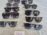 many pairs of sunglasses sitting on a table with a price tag