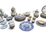 many blue and white plates and cups and saucers