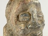 sculpture of a man ' s face made of stone on a white surface