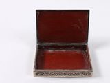an old silver and red box on a white surface