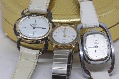 three watches sitting next to each other on a white surface