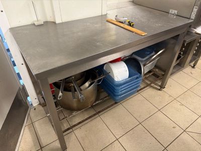 a large stainless steel table with pots and pans on it