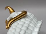 a close up of a white and gold plate with a gold handle