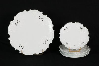 two white plates with lacy designs on them on a black background