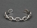 a close up of a silver bracelet on a black surface
