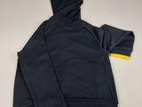 a close up of a black and yellow hoodie on a white surface